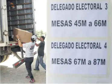  ?? AFP ?? Trabajador­es descargan material electoral para ubicarlas en el estadio Nacional en Santiago, con miras a las elecciones para elegir presidente y senadores durante la jornada prevista para mañana.