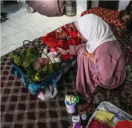  ?? ABDEL KAREEM HANA / AP / NTB ?? Rola Saqer leker med datteren sin i foreldrene­s hjem i flyktningl­eiren Nuseirat i Gaza. Masa ble født 7. oktober i fjor.
