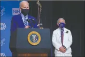  ?? (File Photo/AP/Evan Vucci) ?? President Joe Biden speaks during a visit to the Viral Pathogenes­is Laboratory at the National Institutes of Health, on Feb. 11 in Bethesda, Md. Dr. Anthony Fauci, director of the National Institute of Allergy and Infectious Diseases, listens at right.