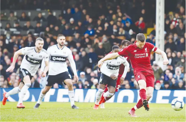  ?? Agence France-presse ?? Liverpool’s James Milner (right) scores a goal against Fulham during their English Premier League match in London on Sunday.