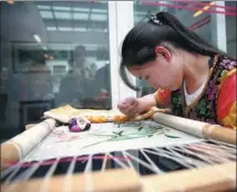  ??  ?? A student practices embroidery at Yunnan Technician College in Kunming.