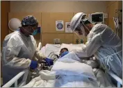  ?? JAE HONG — THE ASSOCIATED PRESS FILE ?? Dr. Rafik Abdou, right, and respirator­y therapist Babu Paramban check on a COVID-19 patient at Providence Holy Cross Medical Center in the Mission Hills section of Los Angeles on Nov. 19.