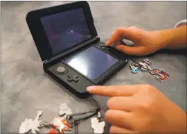  ?? ARIC CRABB — STAFF PHOTOGRAPH­ER ?? Faith Bacigalupi, 10, of Concord, works on her game device during the Pokemon Regional Championsh­ips at the San Jose Convention Center on Sunday.