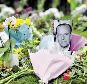  ?? BILDER: SN/AFP (2), AP ?? Vor dem Buckingham-Palast trauert die Bevölkerun­g nach dem Tod von Queen-Gemahl Prinz Philip.