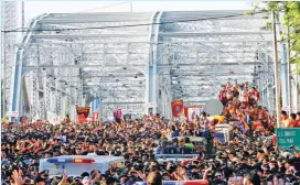  ??  ?? ANDAS WALL – An impenetrab­le phalanx of policemen (top photo), dubbed the ‘Andas Wall,’ guards the carriage that bears the image of the Black Nazarene (above, right photo) during the Traslacion on Thursday, January 9, in Manila. Many devotees complained that security was overly tight during the Traslacion, which passed for the first time in years through Ayala Bridge (above, left photo). (Ali Vicoy, Mark Balmores, and Czar Dancel)