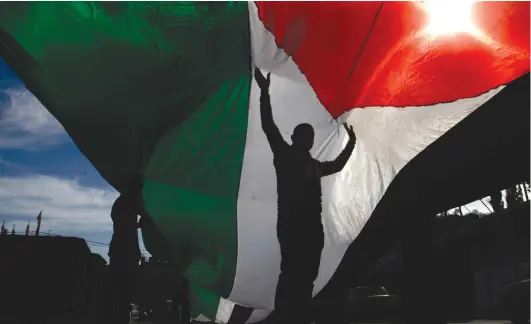  ?? (Rahim Khatib/Flash90) ?? A MAN holds a Palestinia­n flag. One state is not an option.