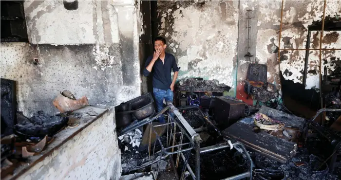  ?? Reuters ?? The explosion damaged many shops and homes in the area, above. An Afghan man, left, who lost his son in the blast, is treated at a hospital in Kabul