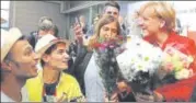 ?? AFP ?? Syrian refugees greet German Chancellor Angela Merkel.