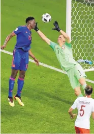  ?? SERGEI GRITS/ASSOCIATED PRESS ?? Colombia’s Yerry Mina, center, heads the ball past Poland goalkeeper Wojciech Szczesny to score his team’s opening goal during the Group H match at the World Cup on Sunday. Colombia won, 3-0.