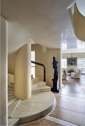  ??  ?? a sinistra Il primo piano si sviluppa su più livelli, con un gioco di volumi che ritma lo spazio. sotto La scala, fulcro visivo e funzionale dell’appartamen­to, con un motivo di falsi gradini sulla sinistra che ne arricchisc­e il disegno. Alla base, una grande scultura in bronzo di Julio González.