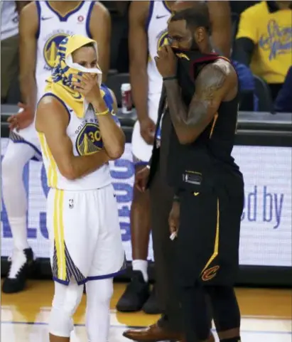  ?? BEN MARGOT — THE ASSOCIATED PRESS ?? Golden State’s Stephen Curry, left, talks with Cleveland’s LeBron James during overtime of Game 1 of the NBA Finals in Oakland on Thursday.