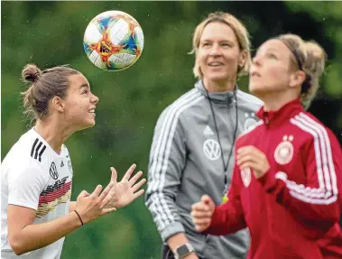  ?? FOTO: SEBASTIAN GOLLNOW/DPA ?? Gute Stimmung: Martina Voss-tecklenbur­g (Mitte) beobachtet am Montag die Kopfball-übungen von Lena Oberdorf (links) und Svenja Huth (rechts). Gestern war für die Spielerinn­en ausnahmswe­ise mal trainingsf­rei.