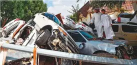  ?? AFP ?? Cars that were washed away by heavy rains are piled up in an alley in the Saudi coastal city of Jeddah yesterday. At least two people died yesterday as heavy rains hit western Saudi Arabia, including the coastal city of Jeddah, delaying flights and forcing schools to close, officials said.