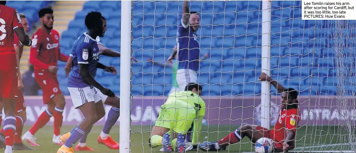  ??  ?? Lee Tomlin raises his arm after scoring for Cardiff, but it was too little, too late PICTURES: Huw Evans