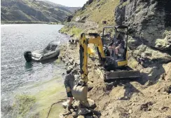  ??  ?? Delicate work . . . Brent Ward, of Lowburn, positions a rock under the watchful eye of Jake Schofield, of Timaru, during the trail’s constructi­on.