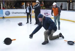  ?? STAFF FILE PHOTO BY C.B. SCHMELTER ?? Slippery When Frozen team member Michael Hall, center, throws a skillet during a previous Skillet Curling Championsh­ip at Ice on the Landing. The local tournament­s are similar to the Olympic sport of curling, in which curling stones (in this case, skillets) are slid across the ice toward a target.