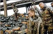  ?? DAVID GOLDMAN/AP ?? Members of the North Carolina National Guard finish stacking sandbags Friday near the rising Lumber River.