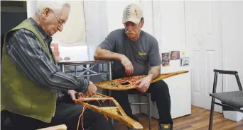  ??  ?? Jérôme Savoie et son fils Donald tressent des raquettes. - Acadie Nouvelle: David Caron