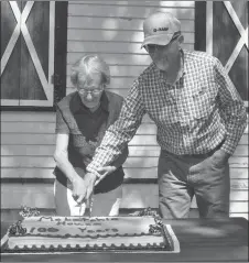  ??  ?? Jean Allen and Greg Nelson cut the cake for the McLatchie house centennial celebratio­n, Aug. 4.