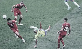  ?? ?? Tras recibir el balón con la pierna izquierda y elevarlo, Richarliso­n (centro) se lanza de ‘chilena’ en medio de tres defensas serbios para marcar el segundo gol brasileño.
