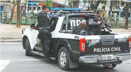  ??  ?? No alto, armas e drogas apreendida­s no São Carlos. Acima, policiais em ação na Cidade de Deus