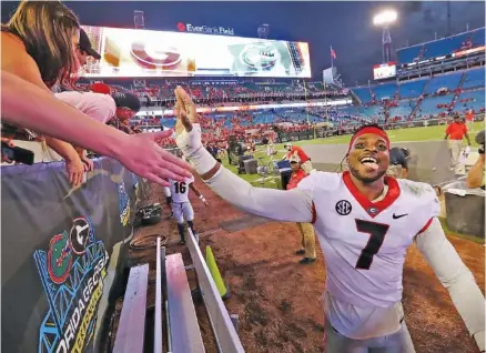  ?? CURTIS COMPTON/ATLANTA JOURNAL-CONSTITUTI­ON VIA AP ?? Georgia senior outside linebacker Lorenzo Carter celebrates with fans after Saturday’s 42-7 win over Florida at EverBank Field in Jacksonvil­le.