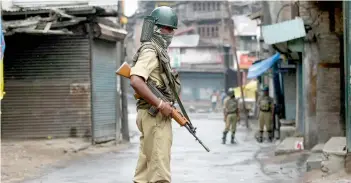  ?? — PTI ?? Security personnel guard a street during curfew in Srinagar on Friday.