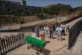  ?? (AP/Bernat Armangue) ?? Residents and migrants in Ceuta, Spain, perform a funeral prayer Saturday for a Moroccan teenager who died Monday trying to swim across the border from Morocco to Spain’s North Africa enclave.