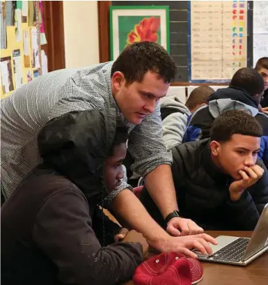  ??  ?? Michael Blaha, a technical lead at One North, helps a pair of students during the “hour of codingg