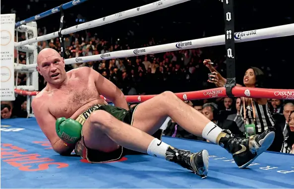  ?? AP ?? Tyson Fury is knocked down during the ninth round of his heavyweigh­t fight against Deontay Wilder, which ended in a draw.