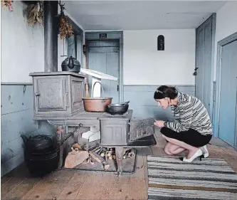  ?? DAVE JOHNSON
THE WELLAND TRIBUNE ?? Port Colborne Historical and Marine Museum director/curator Stephanie Powell Baswick checks over an old stove inside a log cabin on the museum grounds.