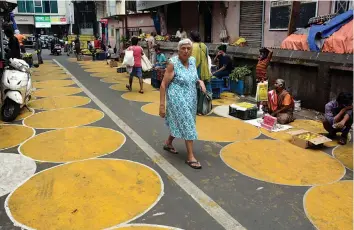  ??  ?? Vendors and customers stand in painted circles to maintain social distancing at Grant Road Market in Mumbai on Friday. —
PTI