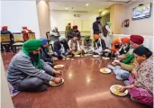  ?? — PTI ?? Farmers leaders eat lunch during the 11th round of talks with the Central government on the new farm laws at Vigyan Bhavan in New Delhi on Friday.