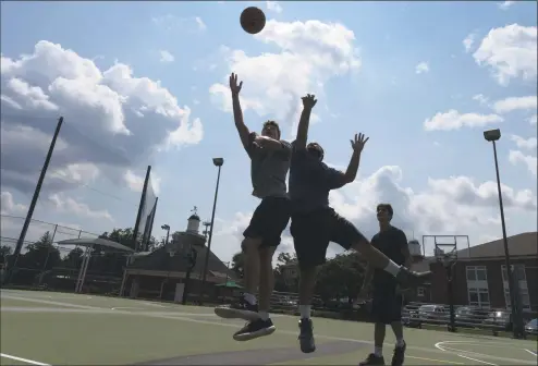  ?? Erik Trautmann / Hearst Connecticu­t Media ?? Ridgefield residents Nick Smart, Sal Drogalis and Ben Smart play hoops under the hot sun at Governors Park in Rdiegfield last Wednesday.