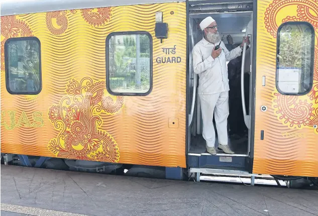  ?? photos by afp ?? A guard communicat­es with the driver during a trial run of the Tejas Express luxury train on Sunday.