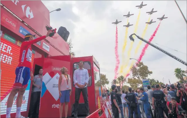  ??  ?? EL LÍDER VUELA. Rudy Molard recibió los honores como maillot rojo, mientras la Patrulla Águila sobrevolab­a los cielos de San Javier.