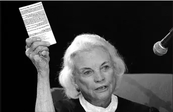  ?? MATT YORK / ASSOCIATED PRESS FILE (2005) ?? Then-supreme Court Justice Sandra Day O’connor holds up a copy of the U.S. Constituti­on Sept. 17, 2005, at an open-air Immigratio­n and Naturaliza­tion citizenshi­p hearing in Gilbert, Ariz.