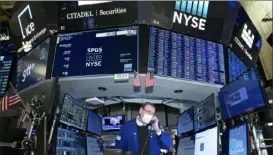  ?? Nicole Pereira/New York Stock Exchange via AP ?? New York Stock Exchange specialist Patrick King works at his post on the trading floor Friday. Stocks ended mixed on a choppy day of trading.
