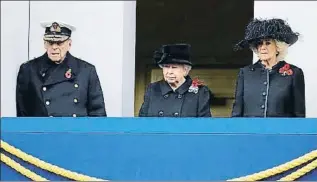  ??  ?? Isabel II siguió la ceremonia desde un balcón junto a su marido y la duquesa de Cornualles; los príncipes Guillermo, Enrique y el duque de York en la ofrenda