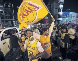  ?? Jason Armond Los Angeles Times ?? LAKERS FANS gather in the street outside L. A. Live to celebrate. Police blocked entrances to the complex and declared an unlawful assembly in downtown L. A.