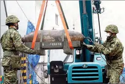  ?? KYODO NEWS VIA GETTY IMAGES ?? Personnel from the Japan Ground Self-Defense Force remove an unexploded World War II bomb at a constructi­on site in Nagoya, central Japan, on April 24.