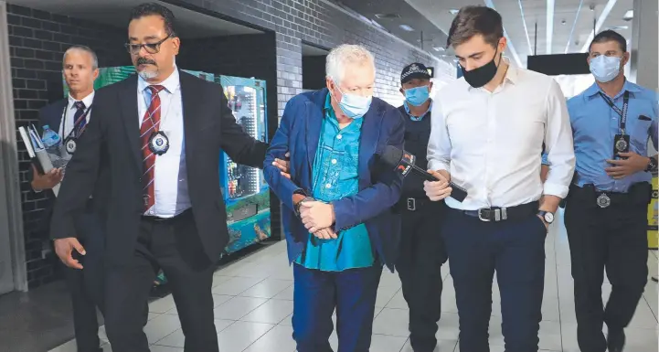  ?? ?? James Blake Blee is escorted through the Cairns domestic airport terminal by Queensland Police officers and detectives to be extradited to New South Wales. Picture: Brendan Radke