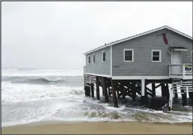  ?? AP PHOTO ?? Waves wash ashore hitting a house as winds and storm surge from Tropical Storm Maria lash North Carolina’s Outer Banks as the storm moves by well off-shore on Wednesday.