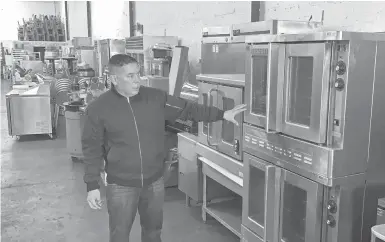  ?? TERRYCHEA/AP ?? Jose Bonilla Jr. shows a used industrial oven for sale last month at his family’s business, American Restaurant Supply in San Leandro, California. The COVID-19 pandemic has forced thousands of restaurant­s nationwide to permanentl­y shut their doors.