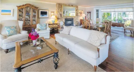  ??  ?? The living room has huge windows on both sides and views can be enjoyed looking right through the house. The matching chair and sofa are heirloom pieces from Bettyanne’s mother, dating back to 1940, restored and reupholste­red by antique expert Michael Hartmann of Nanaimo. Carpets are silk and wool from Turkey.