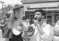  ?? Jay Janner / Austin American-Statesman ?? A 2013 photo of a police officer ordering Greg Casar, of the Workers Defense Project, to get off the property of a Burger King in Austin speaks volumes.