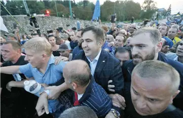  ??  ?? Saakashvil­i is surrounded by his supporters as he arrives at a checkpoint on the Ukrainian-Polish border in Krakovets, Ukraine. — Reuters photo