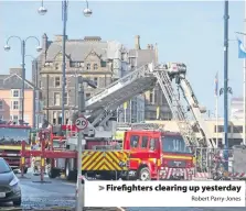  ?? Robert Parry-Jones ?? &gt; Firefighte­rs clearing up yesterday