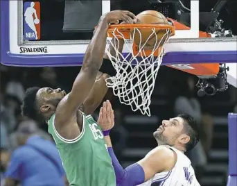  ??  ?? Boston’s Jaylen Brown, left, dunks against Orlando’s Nikola Vucevic Wednesday night in Orlando, Fla.