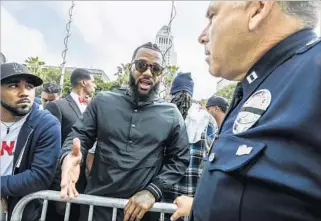  ?? Irfan Khan Los Angeles Times ?? RAPPER THE GAME, center, talks to Capt. Andy Neiman outside the LAPD’s headquarte­rs.